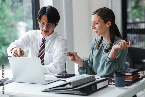 Young confident business people sitting at the office table working on laptop computer with partner, Business meeting consult. Business concept