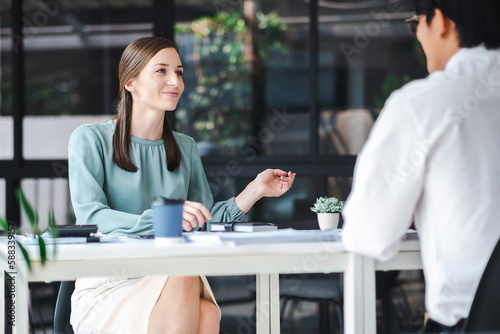 Young confident business people analyze a document with partner, besiness meeting consult. Business concept photo