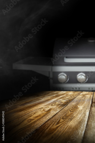 Dark background of silver grill and free space for your decoration on wooden table .  © magdal3na