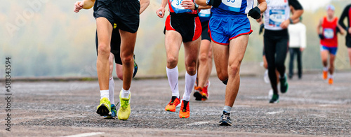 group runners athletes running marathon along river embankment, front view legs jogger run sports race