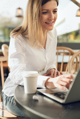 Self employed woman working on laptop in cafe in sunlight Free Download Self employed woman working on laptop in cafe in sunlight - GFXLoad