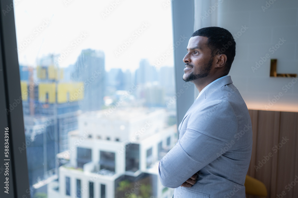 Young businessman sit and relax in the relaxation room by the window overlooking the beautiful city buildings. along with the phone to talk about business. Young businessman sit and relax in the relaxation room by the window overlooking the beautiful city buildings. along with the phone to talk about business.