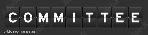 Black color analog flip board with word committee on gray background