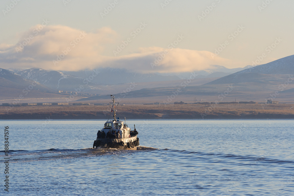 Passenger boat sailing on the estuary. Crossing the river in a small ship. Water transport and passenger transportation in the Russian Far East. Anadyr estuary, Chukotka, Siberia, Russia.