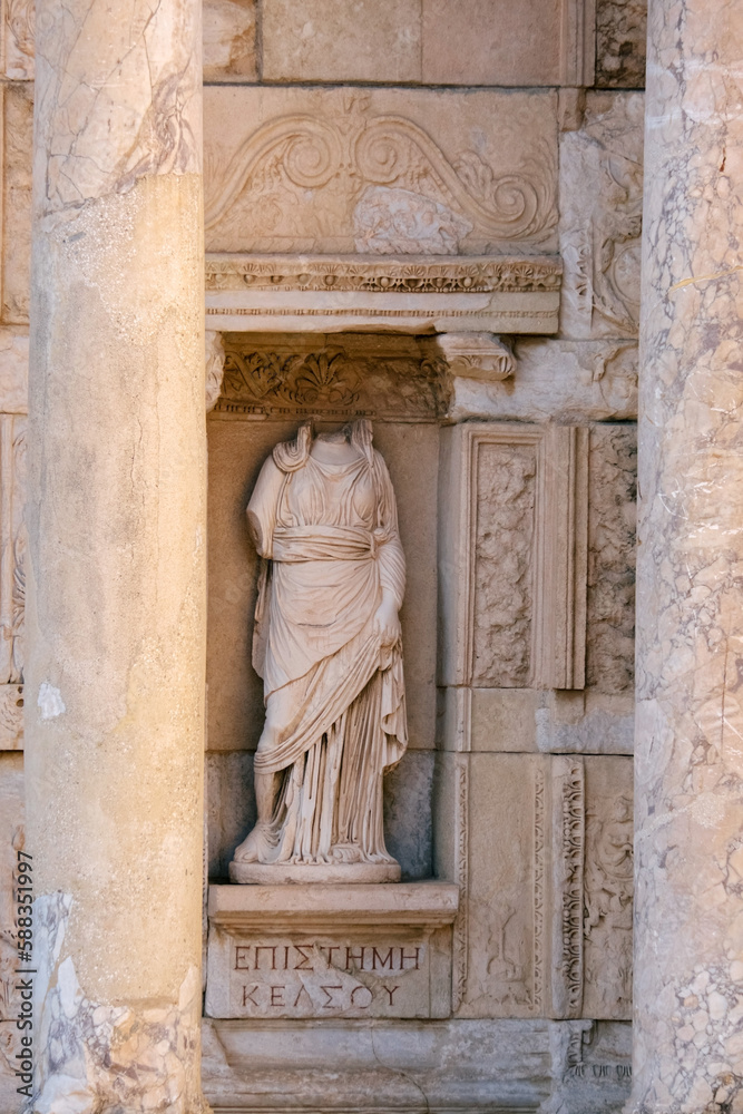 An ancient marble statue of a woman in a toga. Part of the exterior of The Celsus Library of Ephesus Ancient City.