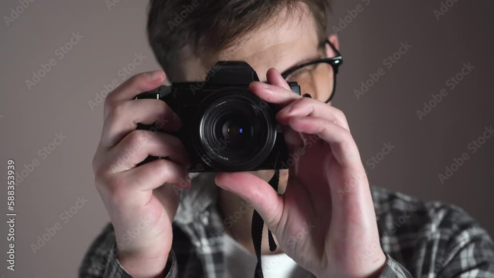Young hipster man taking pictures with a retro camera. slide. studio Young hipster man taking pictures with a retro camera. slide. studio