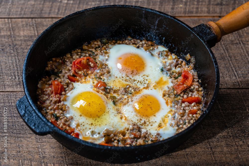 Boiled buckwheat with fried eggs, red peppers, tomato and onions, closeup, Ukraine. Food background. Healthy food Boiled buckwheat with fried eggs, red peppers, tomato and onions, closeup, Ukraine. Food background. Healthy food