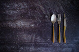 Spoon, fork and knife on a rustic wooden table