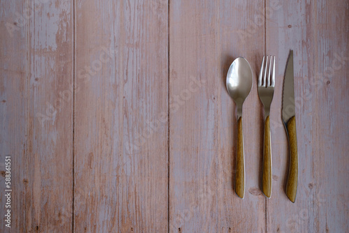 Spoon, fork and knife on a rustic wooden table