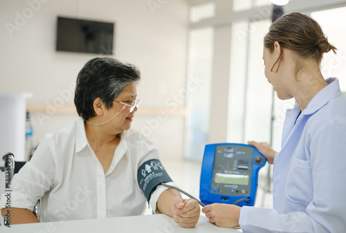 Young female doctor health examining to an old female patient and her family sitting in a wheelchair.