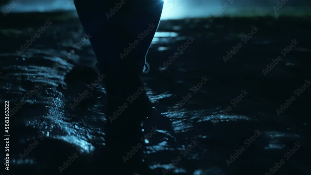 A man walking in the dark through the fog and darkness after the rain.