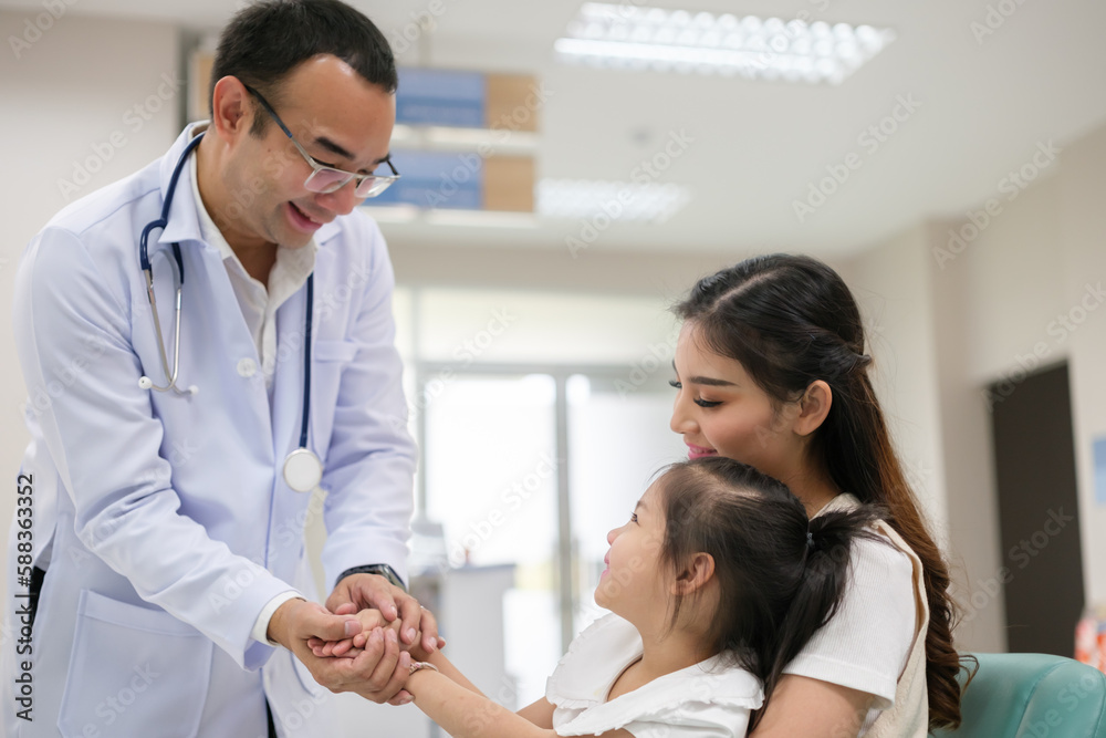 The doctor held the young patient's hand, and the mother smiled and encouraged her. The doctor held the young patient's hand, and the mother smiled and encouraged her.