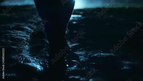 A man walking in the dark through the fog and darkness after the rain.