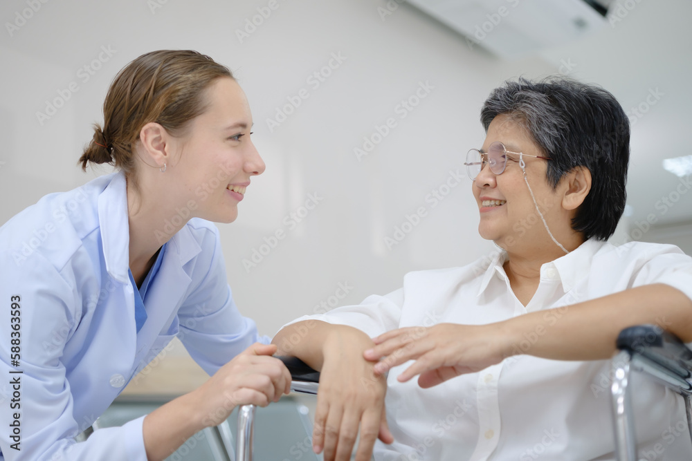 Obraz premium Young female doctor health examining to an old female patient and her family sitting in a wheelchair.