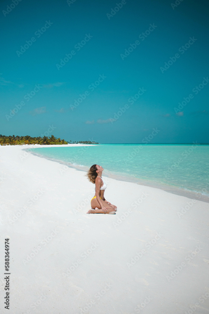 Obraz premium Young Woman In Bikini Enjoying The Sun On The White Sand Beach In Maldives