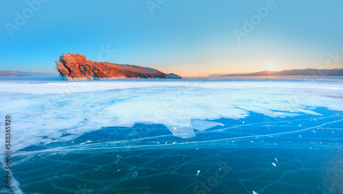 Ogoy island on winter Baikal lake with transparent cracked blue ice at sunrise - Baikal, Siberia, Russia