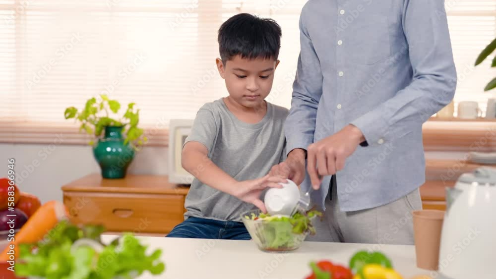 4K, Close-up handsome boy with chubby cheeks, fruit salad stand big plate with dad for mom eat in her spare time, on father-son holiday next him is father who teaches helps his son. 4K, Close-up handsome boy with chubby cheeks, fruit salad stand big plate with dad for mom eat in her spare time, on father-son holiday next him is father who teaches helps his son.