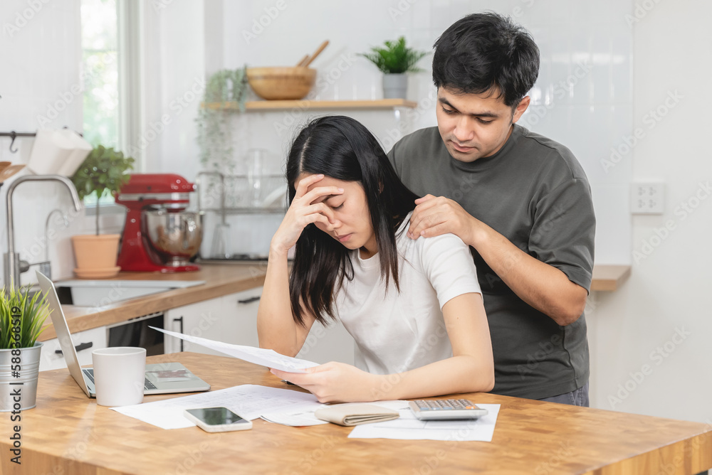 Stressed Asian couple reading notice mail from the bank about unpaid house mortgage Stressed Asian couple reading notice mail from the bank about unpaid house mortgage