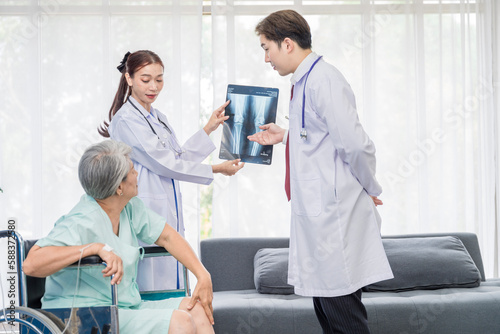 Asian doctor professionally examining a patient's x-ray to analyze the disease for the patient