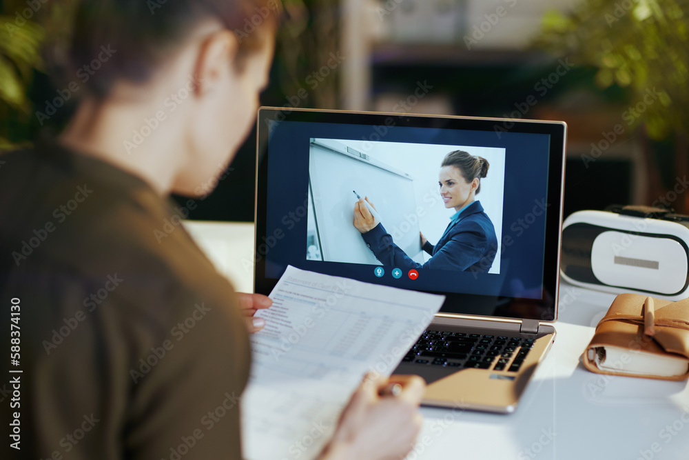 Seen from behind modern business woman using video chat Seen from behind modern business woman using video chat