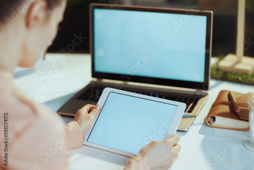 Seen from behind modern woman with laptop blank screen