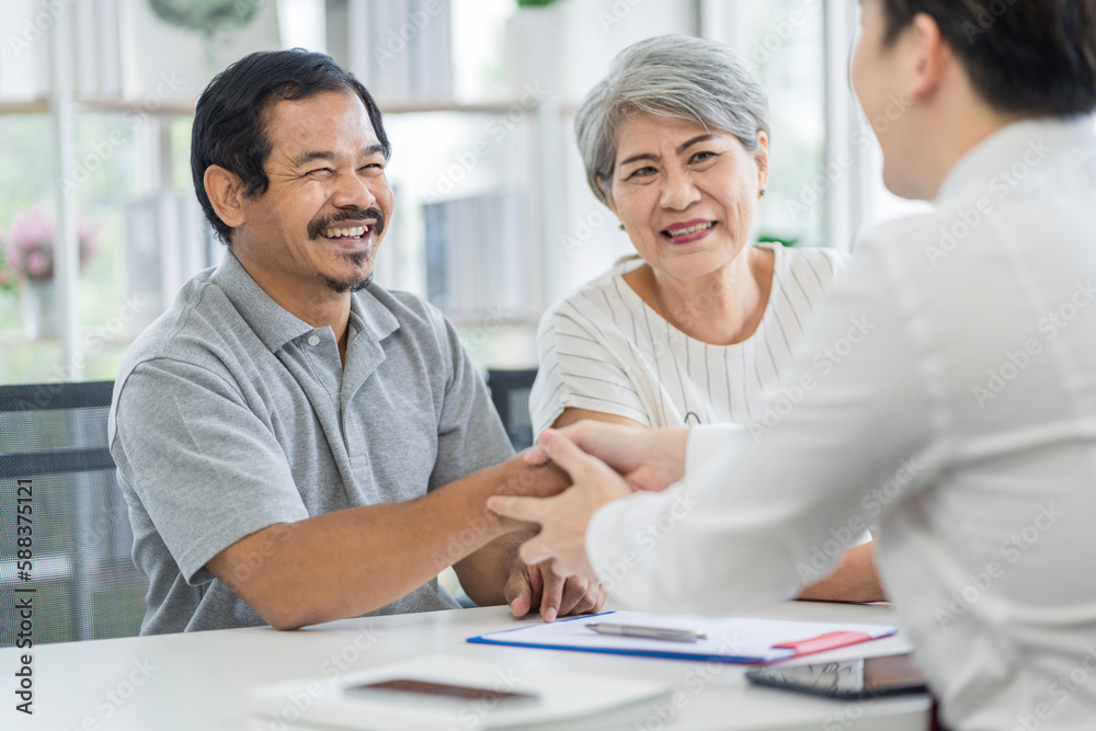 Fototapeta premium Asian seniors who are healthy, in a good mood, smiling, talking with financial or life insurance staff to take care of life after retirement.