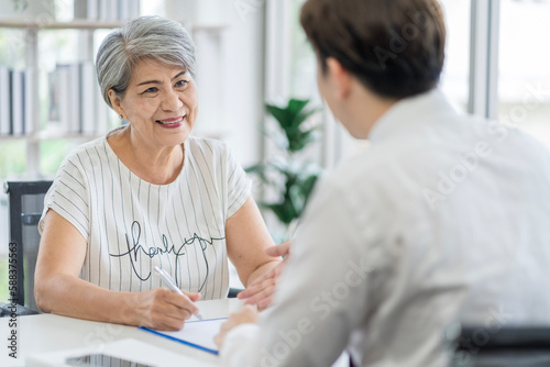 Asian seniors who are healthy, in a good mood, smiling, talking with financial or life insurance staff to take care of life after retirement. © SKW