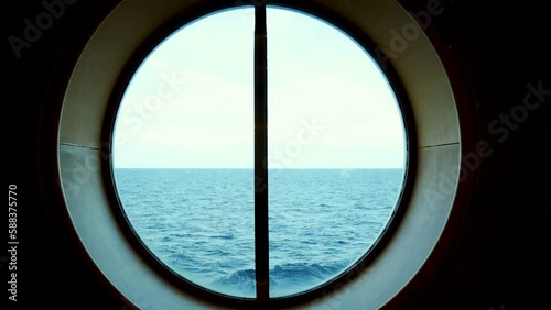 view from the circle window on the cruise overlooking the distant sea waves during ship sailing