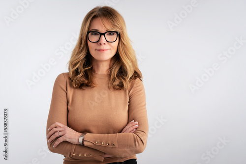 Confident mid aged woman studio portrait against isolated white background