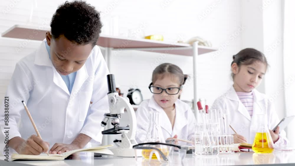 Primary school education in science laboratory classroom concept, pupil in gown uniform research or discover experiment in Chemistry lab, national multi-ethnicity student have fun scientific equipment Primary school education in science laboratory classroom concept, pupil in gown uniform research or discover experiment in Chemistry lab, national multi-ethnicity student have fun scientific equipment