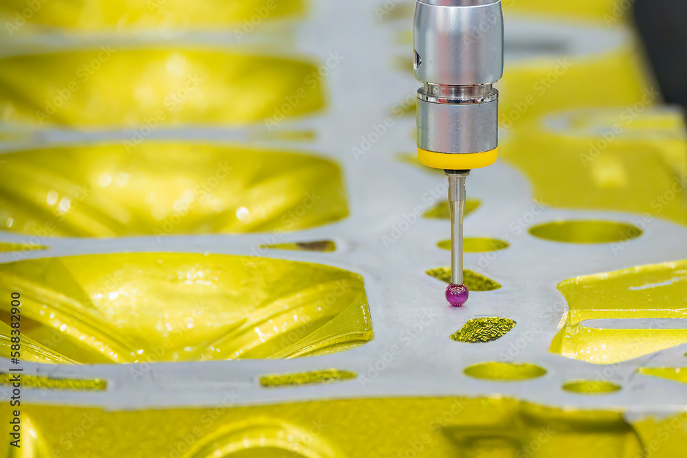 The CMM machine measuring the aluminum cylinder head parts . The