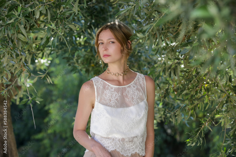Fashion portrait of woman in white lace top with greenery behind, summer vacation fashion Fashion portrait of woman in white lace top with greenery behind, summer vacation fashion