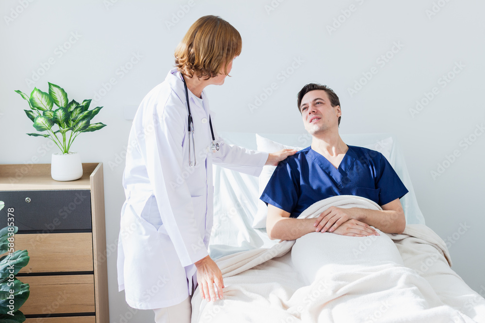Obraz premium the doctor is examining the patient in the hospital. Caucasian female doctor talking to male patient lying in hospital bed.