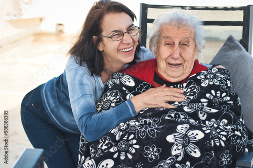 A middle-aged woman and a old woman having fun together and laughing photo