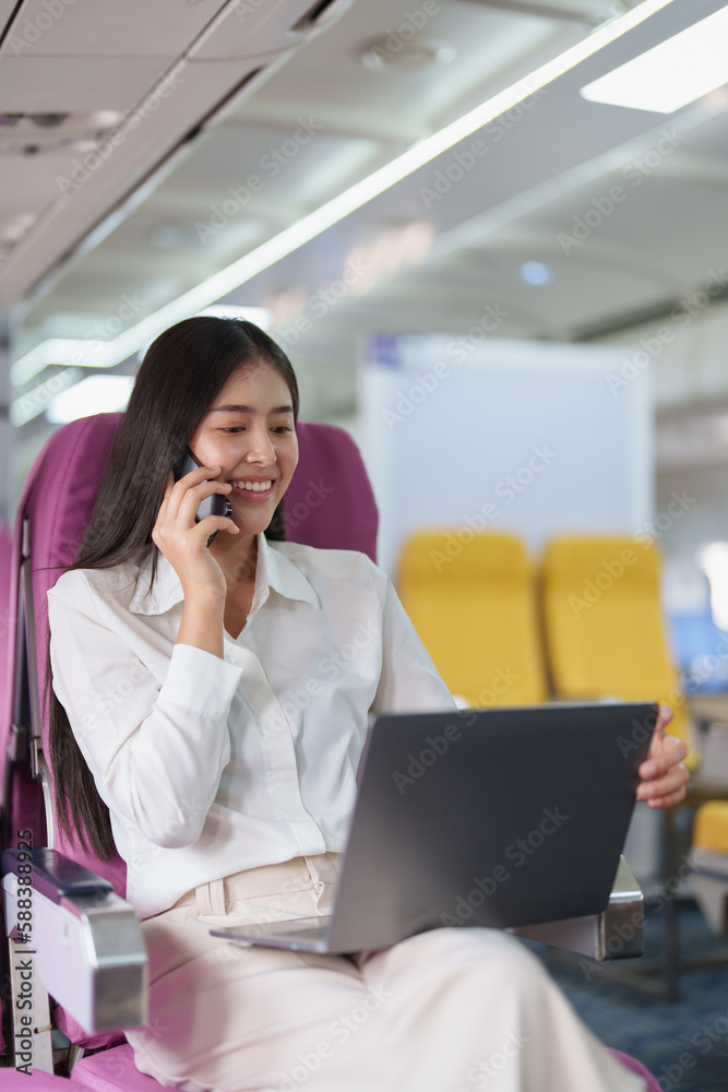 Asian business woman passenger sitting on business class luxury plane while working using smart phone mobile talking or video conference and travel concept Asian business woman passenger sitting on business class luxury plane while working using smart phone mobile talking or video conference and travel concept