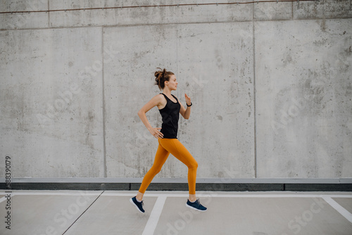 Young woman jogging in a city, healthy lifestyle and sport concept.