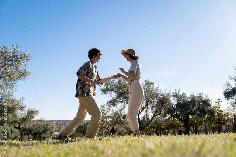 couple of lgbt women dancing in nature outside with sunset light couple of lgbt women dancing in nature outside with sunset light
