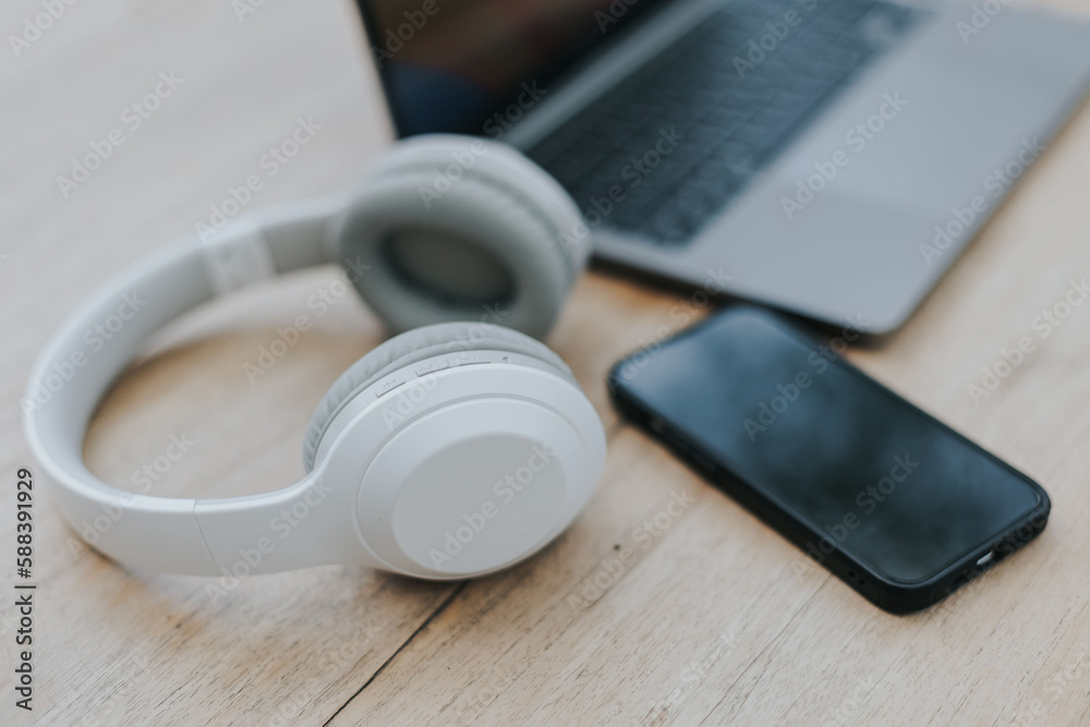 Modern wireless headphones and laptop computer while resting. Set up a workspace or home office to work from home. Modern wireless headphones and laptop computer while resting. Set up a workspace or home office to work from home.