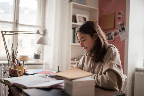 Young teenage girl studying in her room. © Halfpoint