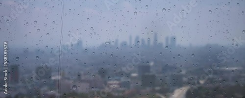view of the city's population density seen from behind the glass of multi-storey buildings when it rains