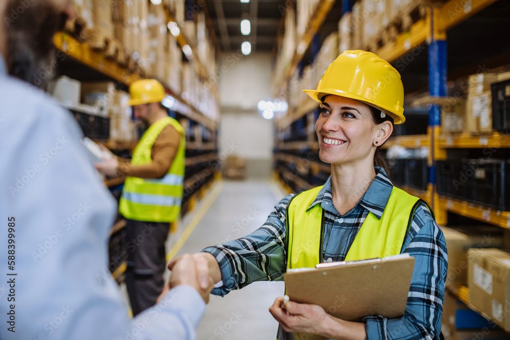 Manager shaking hands with employers in warehouse. Manager shaking hands with employers in warehouse.