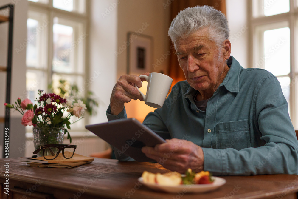 Senior man reading something in digital tablet. Senior man reading something in digital tablet.