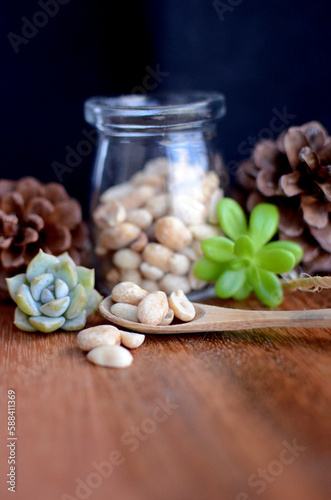 Peanut in jar with wooden and black background. Vertical