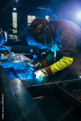Welder industrial worker welding with gas torch.