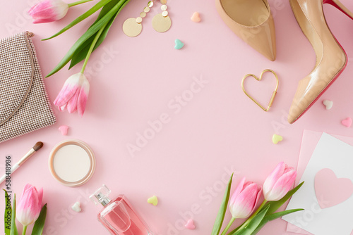 Flat lay photo of trendy woman shoes makeup powder and brush perfume bottle handbag postcard with heart and pink tulips on pastel pink background with empty space in the middle. Mother's Day concept