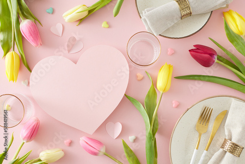 Mother's Day concept. Top view photo of pink hearts circle plates cutlery knife fork fabric napkin with gold ring empty glasses and tulips on pastel pink background with blank space