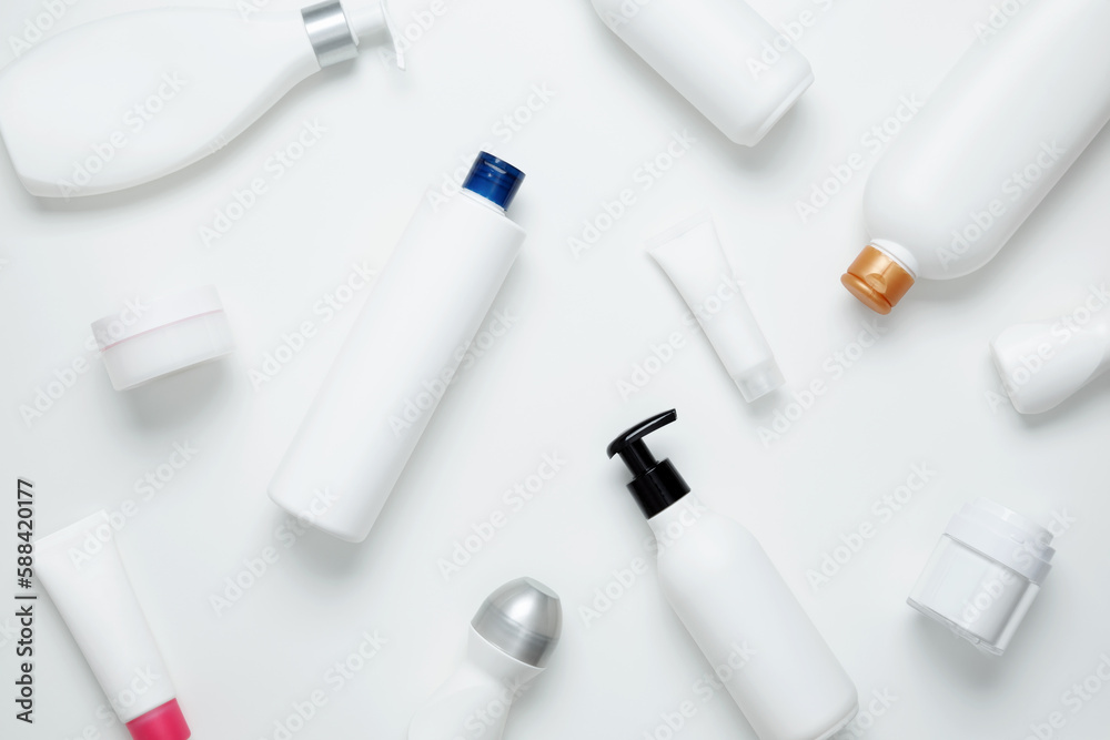 Cosmetic beauty products on white background. Bottles and tubes with branding mock up. Skin care and beauty concept. Top view, flat lay, copy space