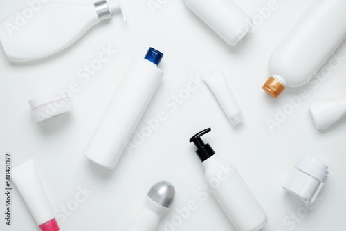 Cosmetic beauty products on white background. Bottles and tubes with branding mock up. Skin care and beauty concept. Top view, flat lay, copy space