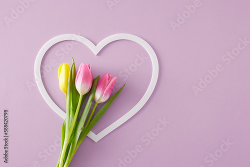 Mother's Day concept. Creative layout made of heart shaped frame colorful tulips flowers on isolated lilac background. Flat lay with blank space #588420798
