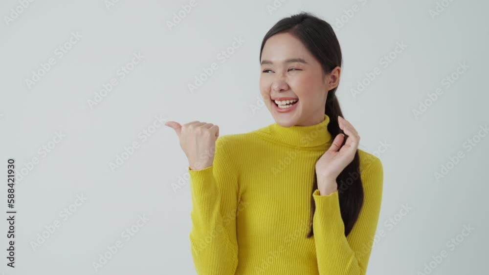 Portrait asian beautiful girl pointing blank space isolated background. Happy woman pointing on something. young female standing pointing finger sideways, billboard, introduction, advertisement, space Portrait asian beautiful girl pointing blank space isolated background. Happy woman pointing on something. young female standing pointing finger sideways, billboard, introduction, advertisement, space